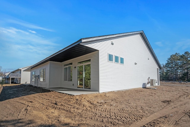 rear view of property with a patio area and central air condition unit