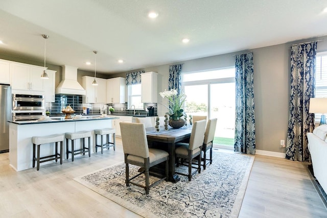 dining space with light wood finished floors, baseboards, and a wealth of natural light