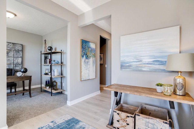 office area with beam ceiling, light wood-style floors, and baseboards