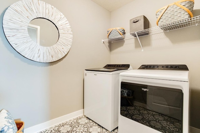 laundry area with light tile patterned floors, laundry area, baseboards, and separate washer and dryer