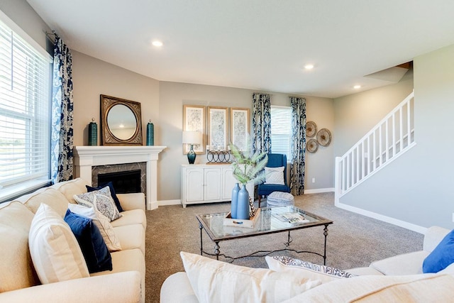 carpeted living area with stairs, recessed lighting, a fireplace, and baseboards