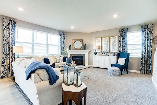 living area with plenty of natural light, recessed lighting, baseboards, and a premium fireplace