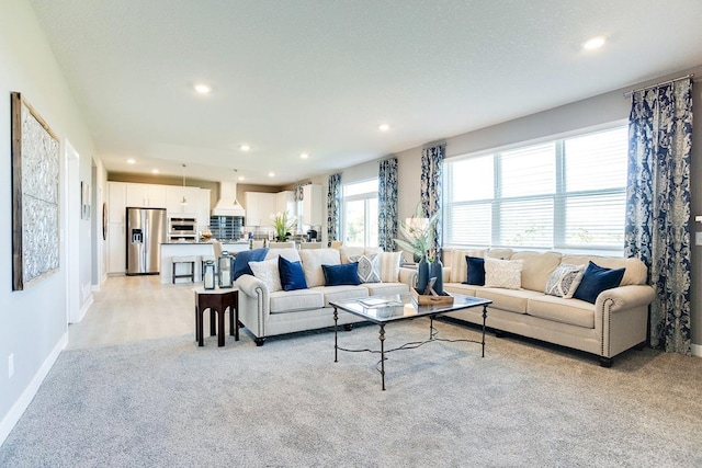 living room with recessed lighting, baseboards, and light colored carpet