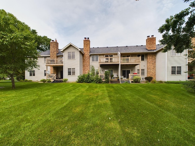 back of property featuring a balcony and a lawn