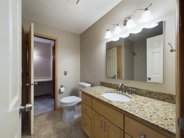 bathroom featuring vanity, a textured ceiling, and toilet