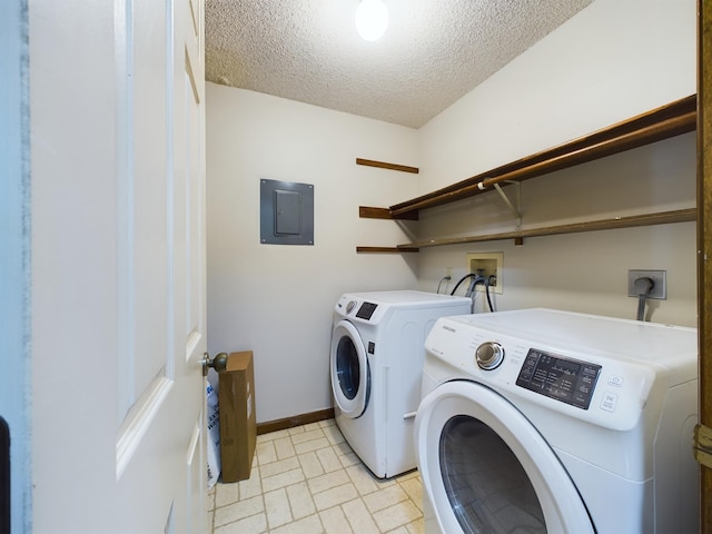 laundry room with a textured ceiling, electric panel, and washing machine and clothes dryer