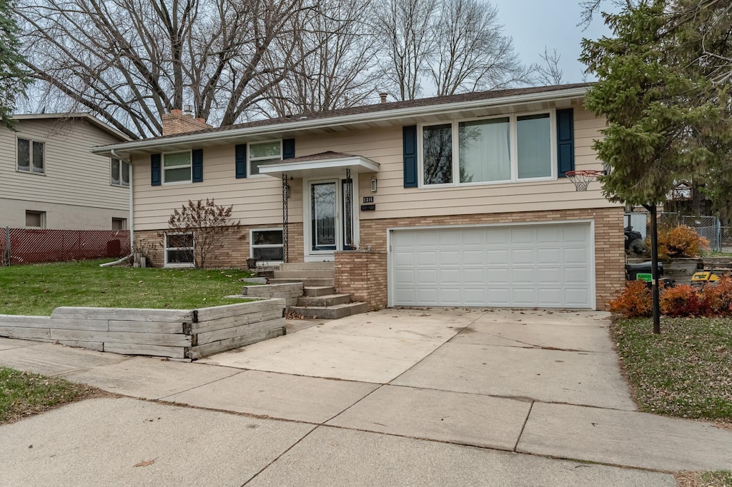 bi-level home with a front lawn and a garage