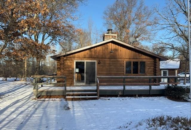 snow covered rear of property featuring a wooden deck