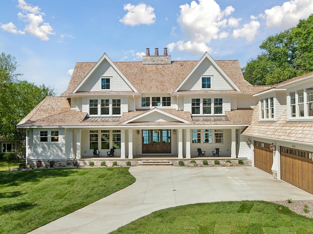 back of property with a yard, a porch, and a garage