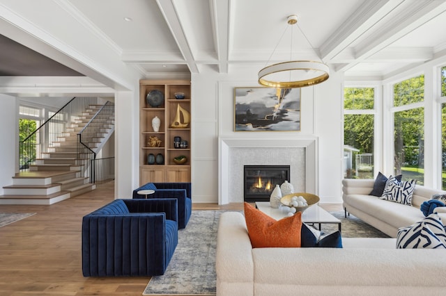 living room with beam ceiling, coffered ceiling, wood-type flooring, a fireplace, and ornamental molding