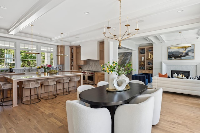 dining space featuring beam ceiling, light wood-type flooring, and crown molding