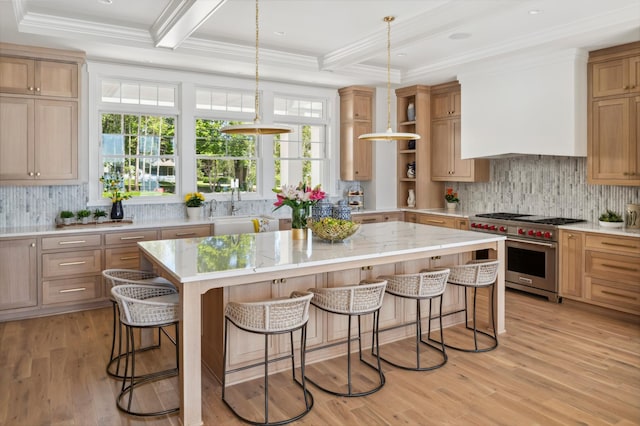 kitchen featuring a kitchen bar, light wood-type flooring, designer stove, beamed ceiling, and a kitchen island