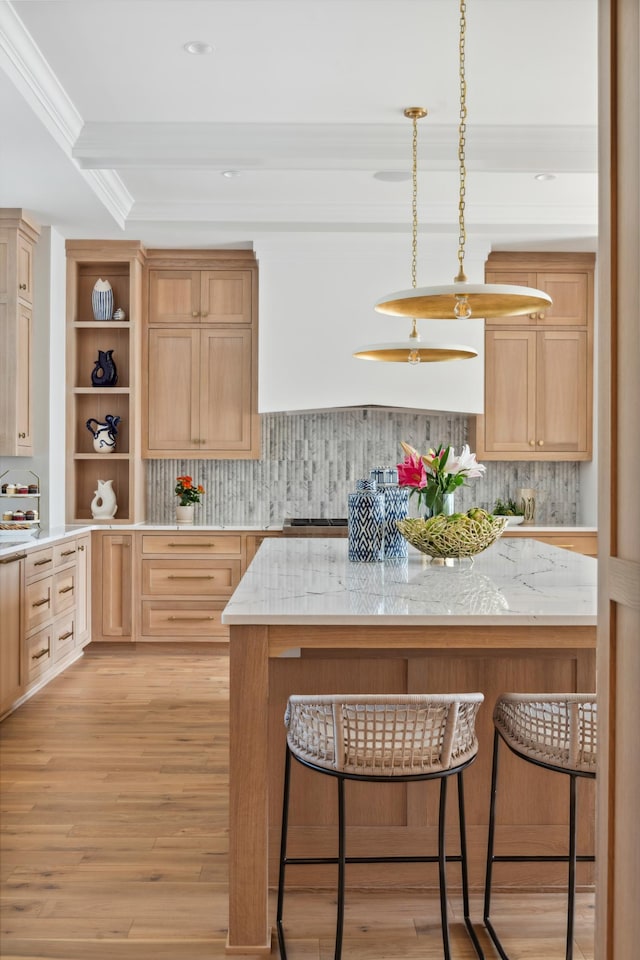 kitchen with hanging light fixtures, light hardwood / wood-style flooring, backsplash, light brown cabinetry, and ornamental molding