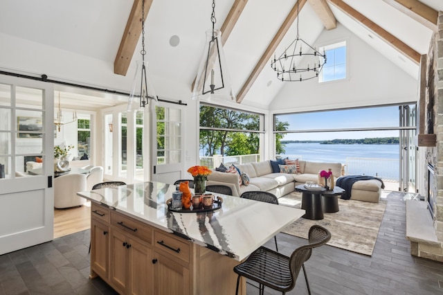 sunroom / solarium with a notable chandelier, lofted ceiling with beams, a barn door, and a water view