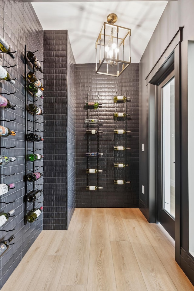 wine room with an inviting chandelier and light wood-type flooring