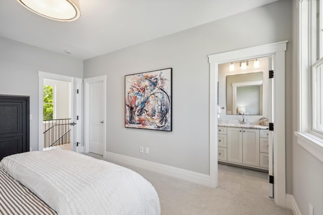 carpeted bedroom with connected bathroom and sink