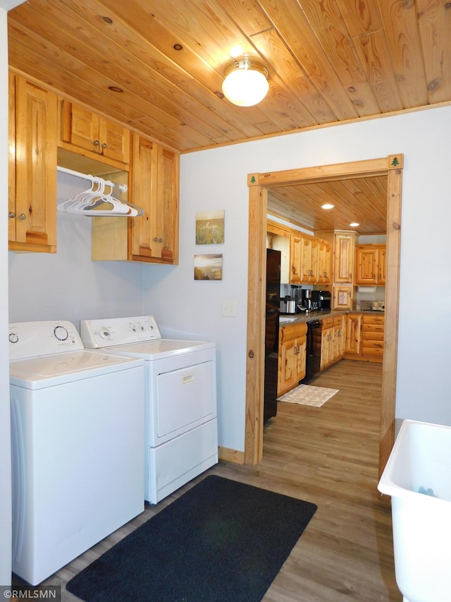 laundry area with washer and dryer, cabinets, light hardwood / wood-style flooring, and wood ceiling