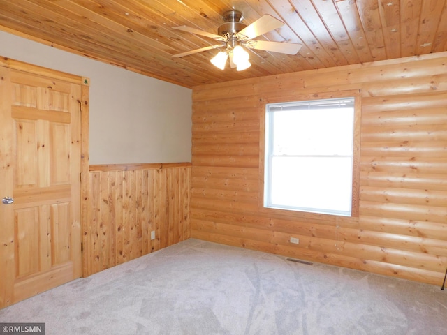 carpeted spare room featuring log walls, wooden ceiling, and ceiling fan