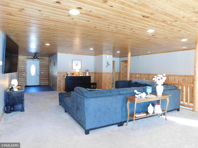 living room with carpet flooring, wood ceiling, and wooden walls