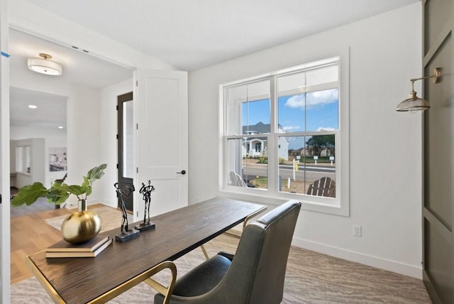 office space featuring light carpet and baseboards