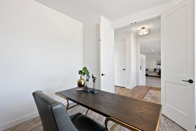 home office featuring baseboards and wood finished floors