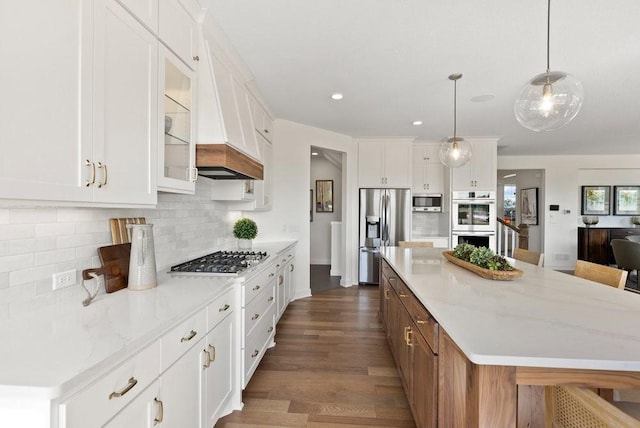 kitchen featuring appliances with stainless steel finishes, a kitchen island, glass insert cabinets, and white cabinetry