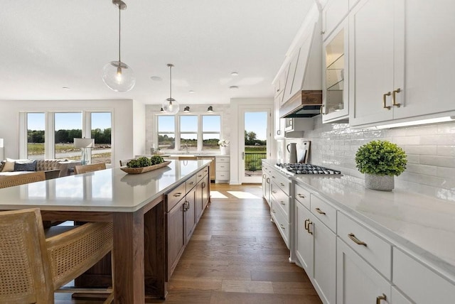 kitchen with glass insert cabinets, premium range hood, pendant lighting, and white cabinets