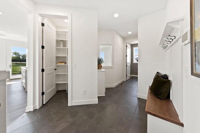 hall with baseboards, recessed lighting, and a healthy amount of sunlight