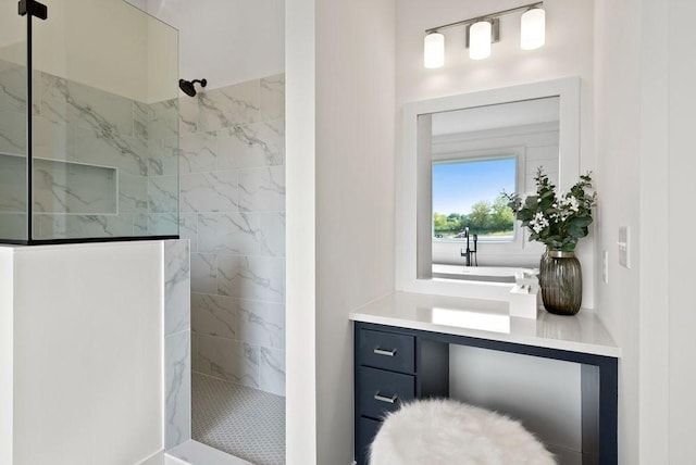 bathroom featuring vanity and a marble finish shower