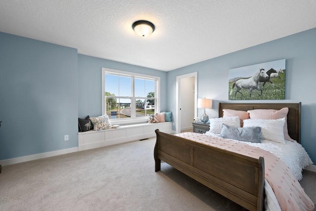 bedroom with carpet, a textured ceiling, and baseboards