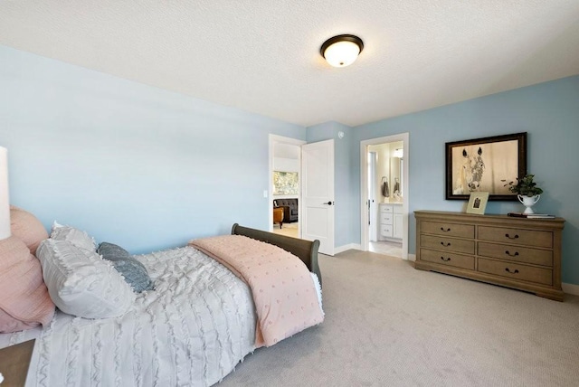 bedroom with light carpet, a textured ceiling, connected bathroom, and baseboards