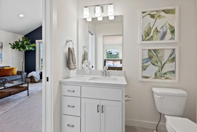 bathroom featuring baseboards, connected bathroom, toilet, vaulted ceiling, and vanity