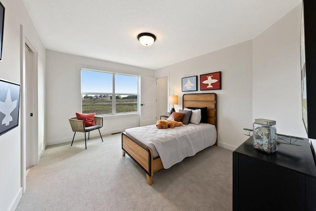 bedroom with light carpet and baseboards