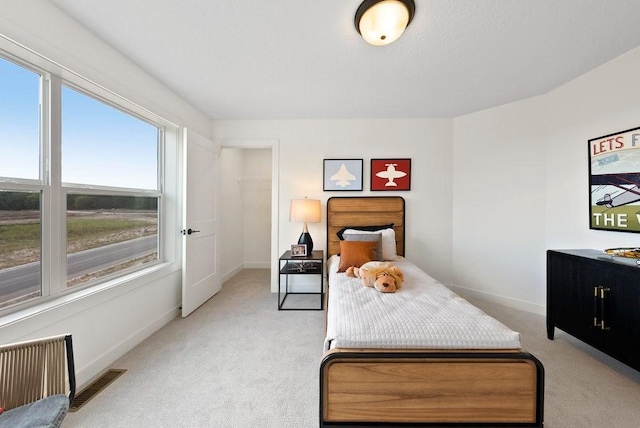 bedroom with visible vents, baseboards, and light colored carpet