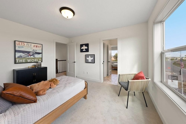 bedroom featuring baseboards and light colored carpet