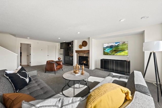 carpeted living area with recessed lighting, a warm lit fireplace, and baseboards