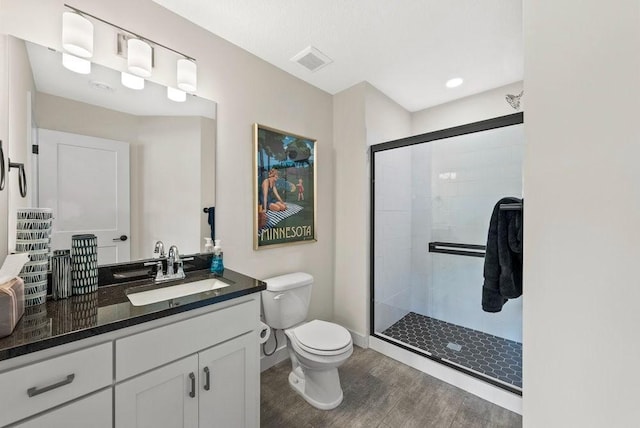 full bathroom with toilet, wood finished floors, vanity, visible vents, and a shower stall