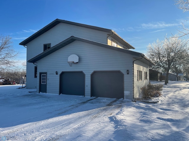 view of snowy exterior with a garage