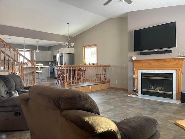 living room featuring ceiling fan with notable chandelier and lofted ceiling