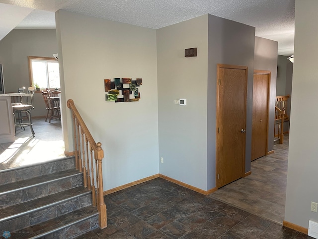 stairs featuring a textured ceiling