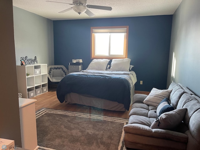 bedroom featuring ceiling fan, hardwood / wood-style floors, and a textured ceiling