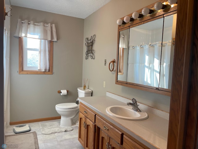 bathroom featuring vanity, a textured ceiling, and toilet