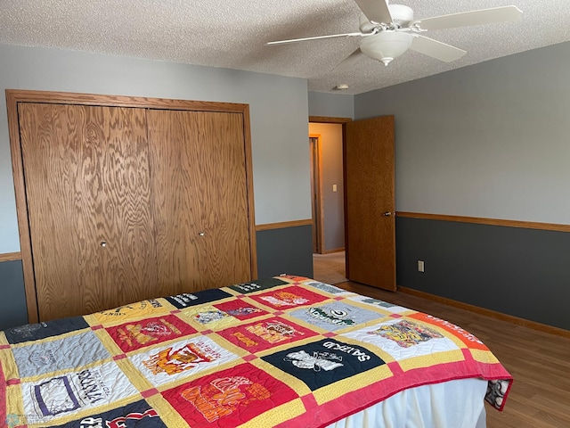 bedroom with ceiling fan, a textured ceiling, and dark wood-type flooring