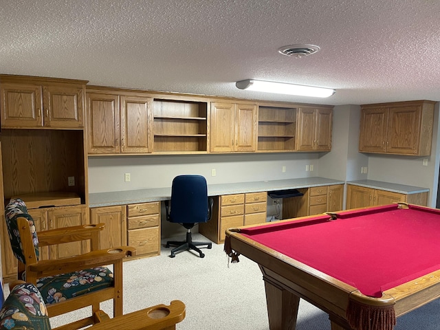 game room featuring light colored carpet, built in desk, a textured ceiling, and billiards