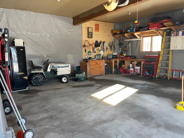 garage with a workshop area and wood walls