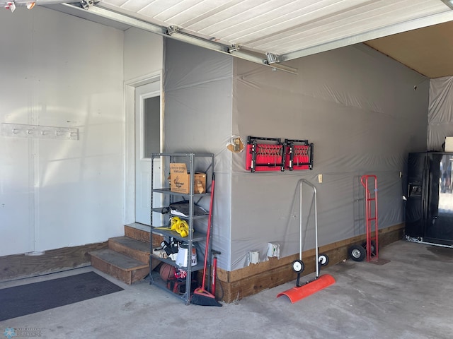 garage with black refrigerator with ice dispenser