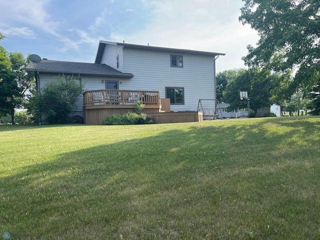 back of property with a lawn and a deck