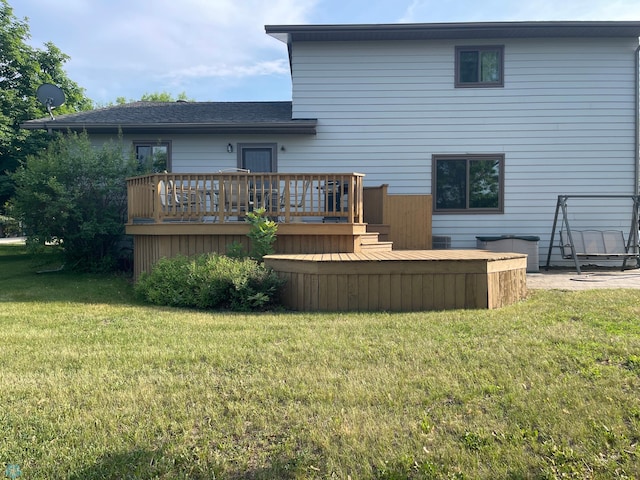 back of property with a yard and a deck