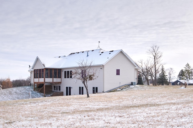 rear view of property featuring a sunroom and central AC