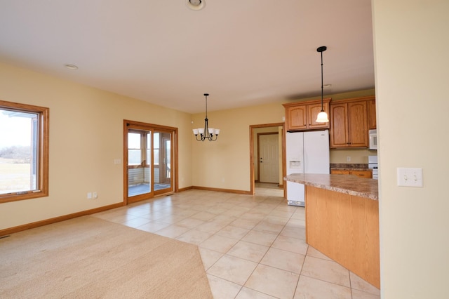 kitchen with white appliances, pendant lighting, a chandelier, plenty of natural light, and light tile patterned flooring